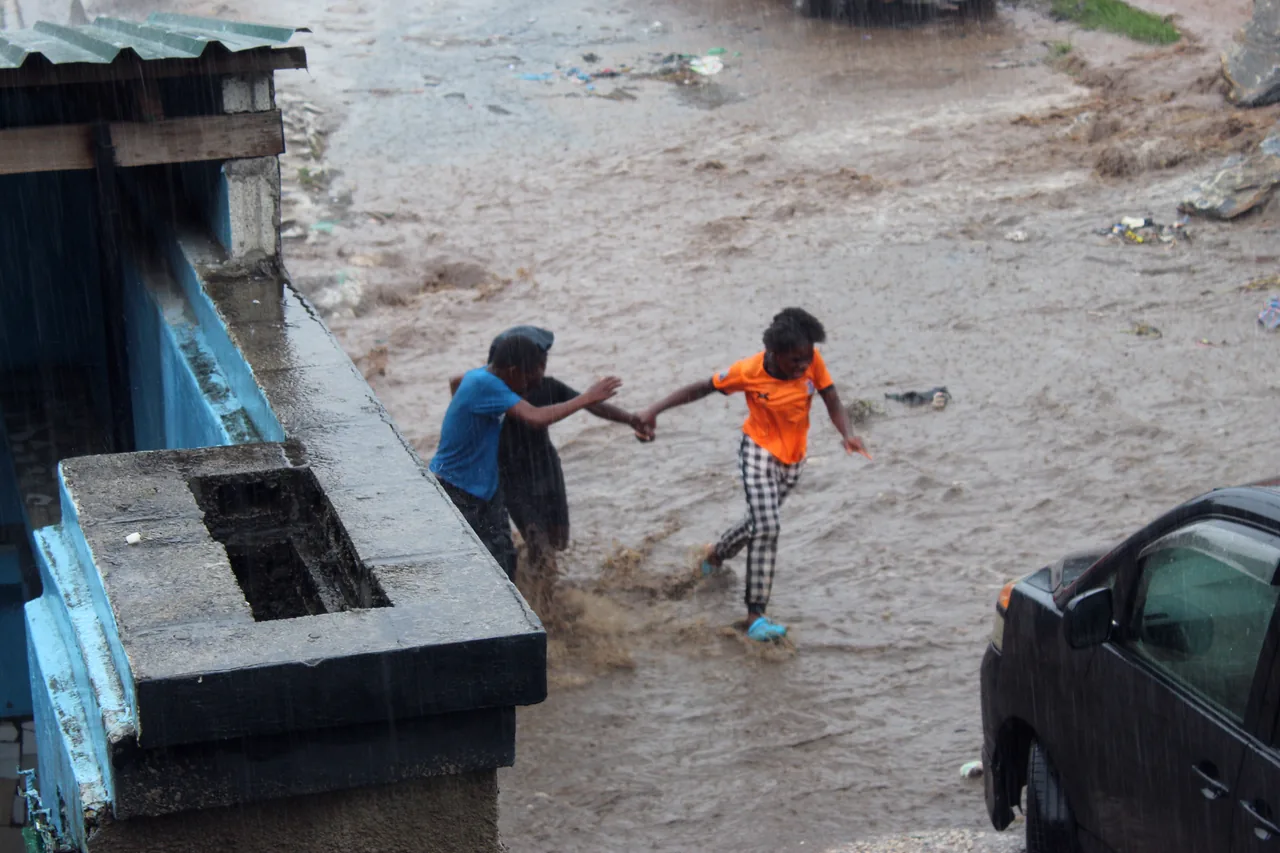 Children crossing a flooded street in Lusaka