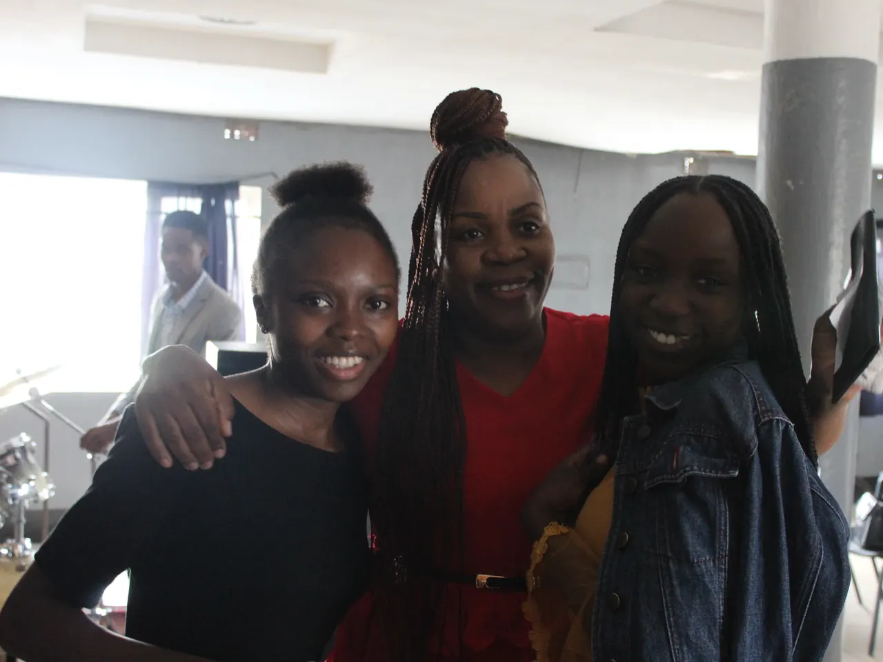 Three friends smile together at church on a Sunday